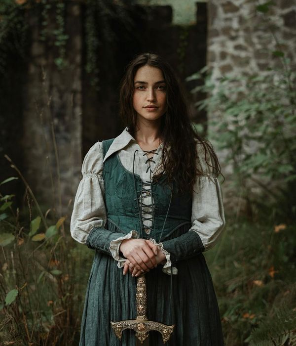 Woman in a calm, focused pose against a dark background with teal accents.